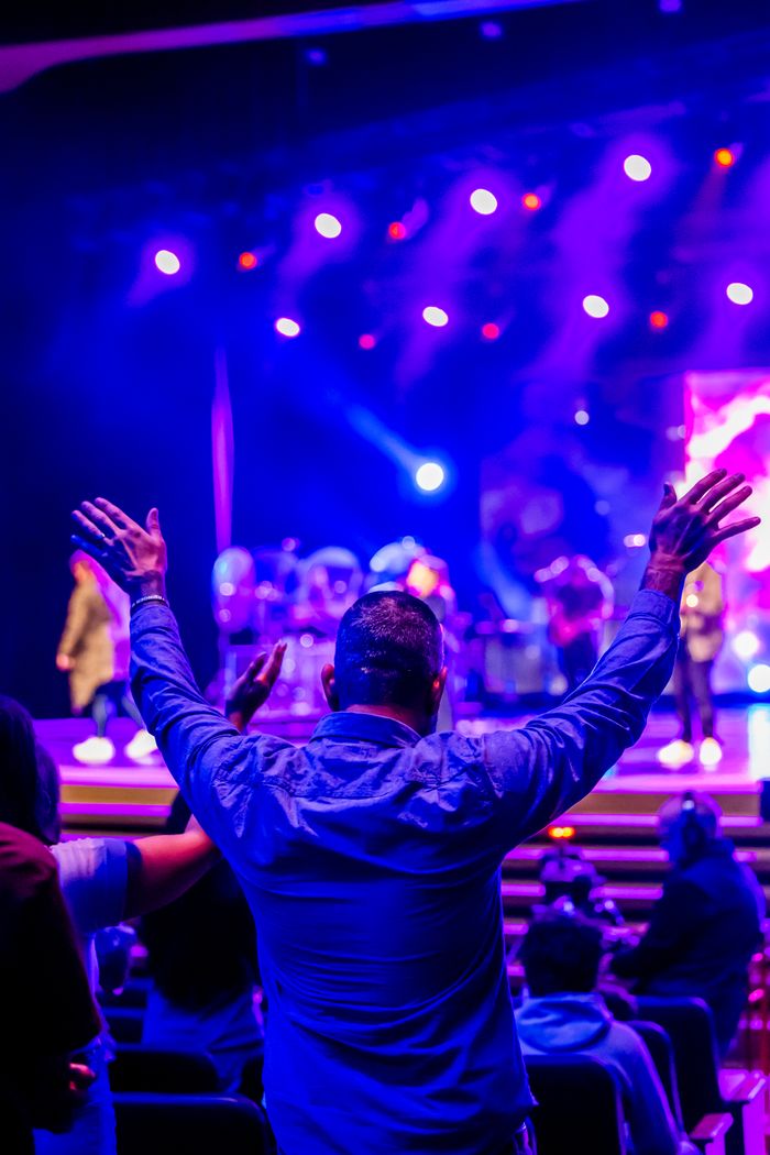 A person enjoying a live concert with vibrant stage lights.