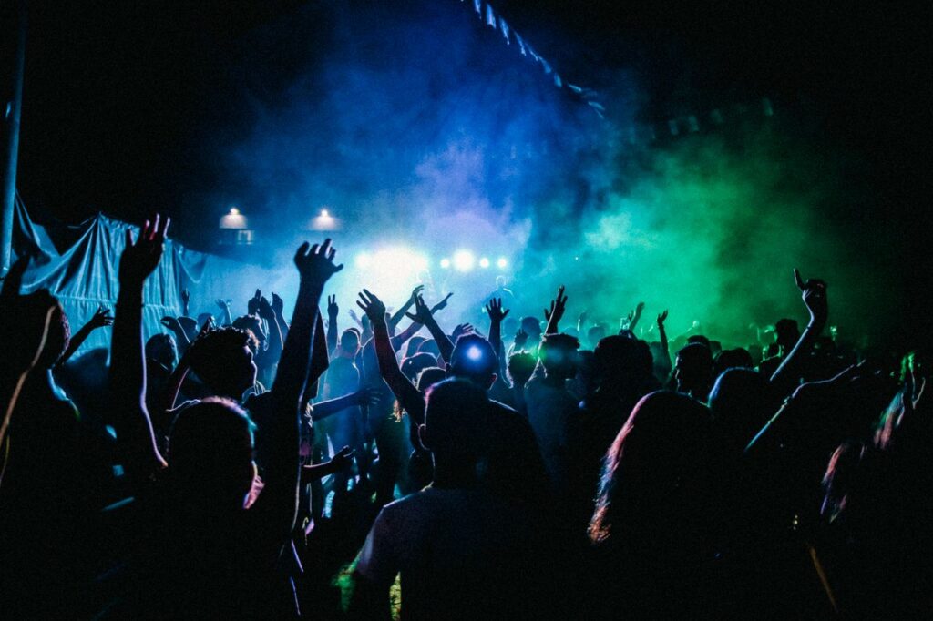 Dynamic scene of a vibrant nightclub with a lively crowd enjoying live music and colorful lights.
